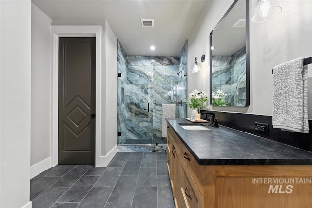 bathroom featuring a marble finish shower, visible vents, baseboards, tile patterned flooring, and vanity
