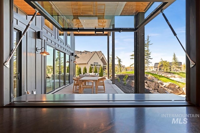 game room with a residential view, a wall of windows, and a high ceiling