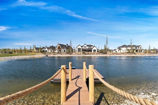 view of dock with a residential view and a water view