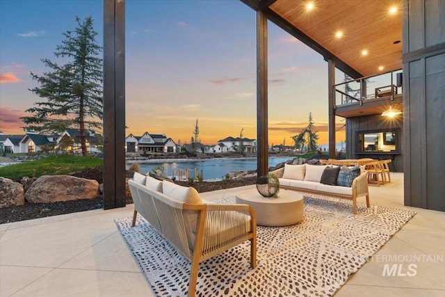 view of patio / terrace with an outdoor living space, a balcony, and a water view