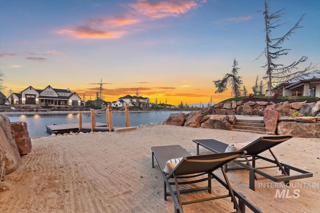 surrounding community with a dock and a water view