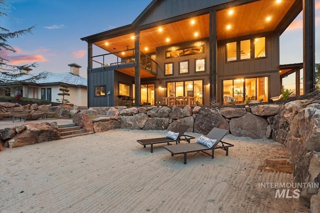 back of property at dusk with a patio area and a balcony