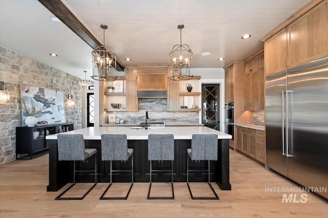 kitchen with open shelves, light countertops, a notable chandelier, and appliances with stainless steel finishes