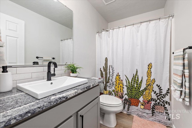full bath with wood finished floors, decorative backsplash, toilet, vanity, and a shower with shower curtain