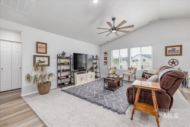 living room with wood finished floors, a ceiling fan, lofted ceiling, and baseboards