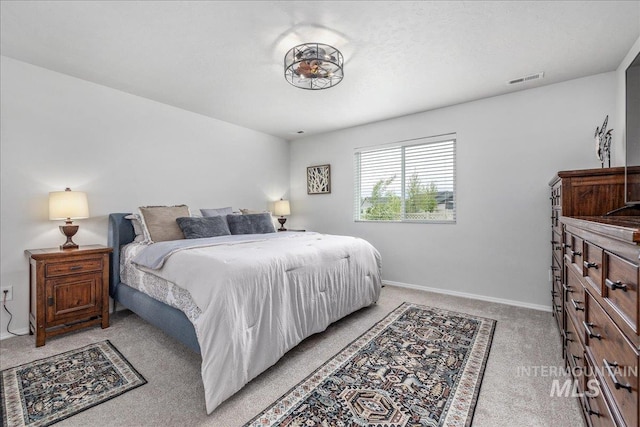bedroom featuring light colored carpet and baseboards