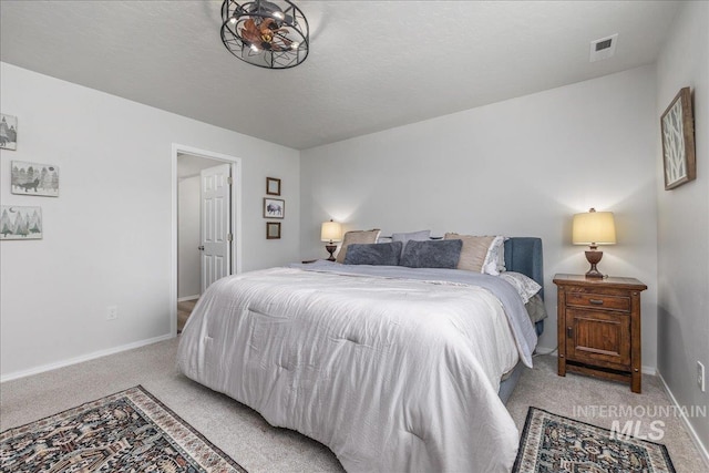 bedroom with light colored carpet and baseboards