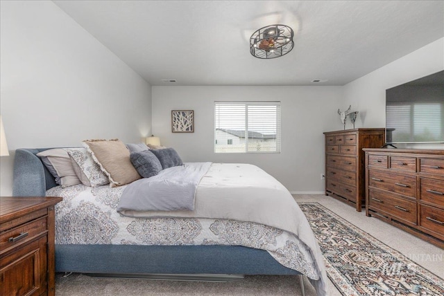 bedroom with light colored carpet and baseboards