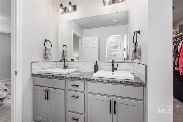 full bathroom featuring tasteful backsplash, double vanity, and a spacious closet