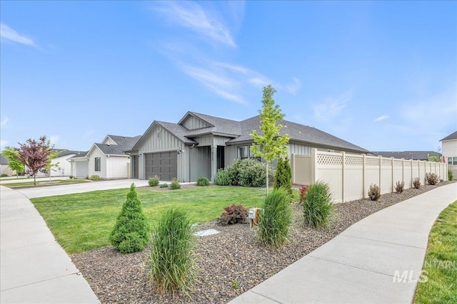 view of front of home with board and batten siding, concrete driveway, an attached garage, and roof with shingles