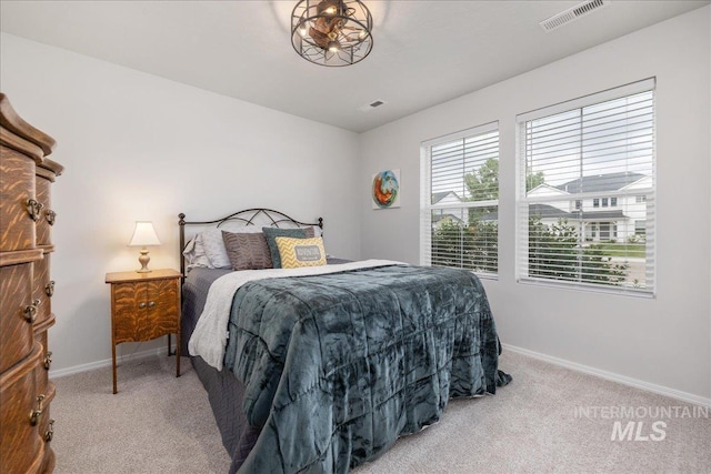 bedroom with light colored carpet and baseboards