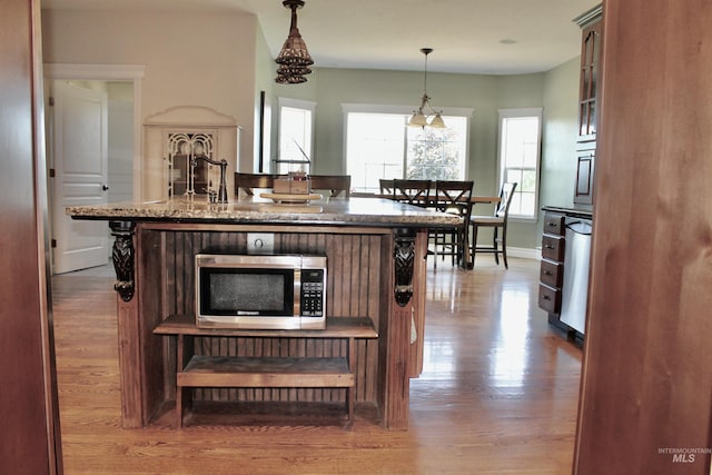 3703 E 3793 N, Kimberly, ID 83341 - kitchen featuring stainless steel microwave, wood finished floors, light stone countertops, and decorative light fixtures