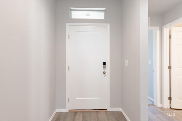 doorway featuring light wood-type flooring and baseboards