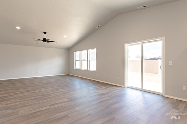 unfurnished room featuring baseboards, lofted ceiling, wood finished floors, and a ceiling fan