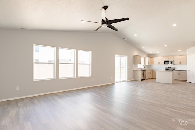 unfurnished living room with visible vents, light wood-style flooring, lofted ceiling, and ceiling fan