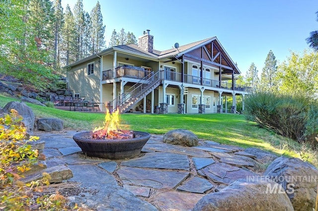 3801 S Carpenter Loop, Post Falls, ID 83854 - rear view of house with a chimney, a patio area, stairway, an outdoor fire pit, and a yard