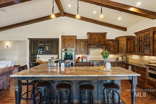 3801 S Carpenter Loop, Post Falls, ID 83854 - kitchen with dark wood-style flooring, stainless steel appliances, light stone countertops, and backsplash