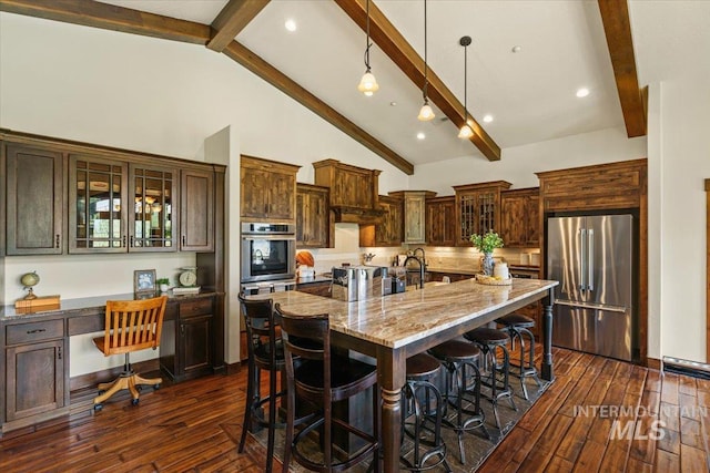 3801 S Carpenter Loop, Post Falls, ID 83854 - kitchen with dark wood-style flooring, beam ceiling, high end fridge, a kitchen bar, and light stone counters