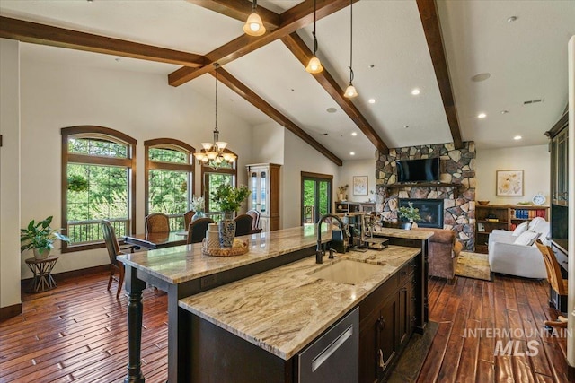 3801 S Carpenter Loop, Post Falls, ID 83854 - kitchen featuring light stone counters, a sink, a stone fireplace, dark wood-type flooring, and pendant lighting