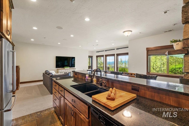 3801 S Carpenter Loop, Post Falls, ID 83854 - kitchen with a sink, dark stone countertops, freestanding refrigerator, recessed lighting, and visible vents