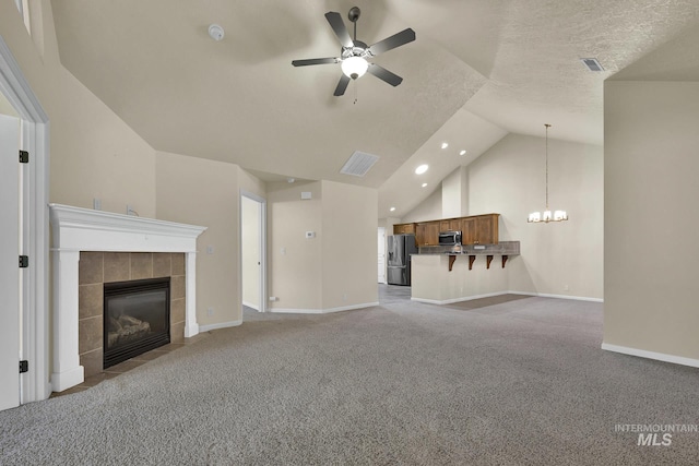 2870 N Cloverdale, Boise, ID 83713 - unfurnished living room with light carpet, a ceiling fan, a chandelier, lofted ceiling, and a tile fireplace