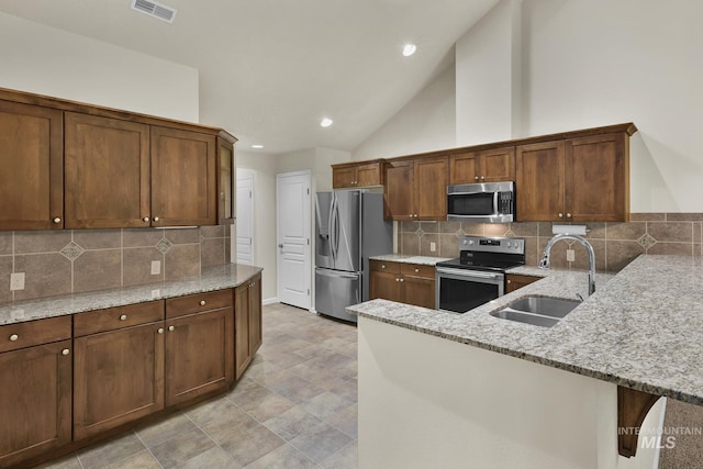 2870 N Cloverdale, Boise, ID 83713 - kitchen with stainless steel appliances, a peninsula, light stone countertops, decorative backsplash, and recessed lighting