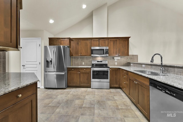 2870 N Cloverdale, Boise, ID 83713 - kitchen with appliances with stainless steel finishes, light stone countertops, decorative backsplash, lofted ceiling, and recessed lighting