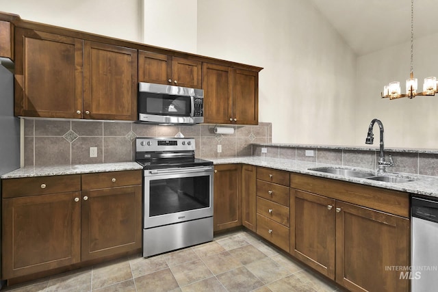 2870 N Cloverdale, Boise, ID 83713 - kitchen with appliances with stainless steel finishes, tasteful backsplash, a chandelier, light stone counters, and decorative light fixtures