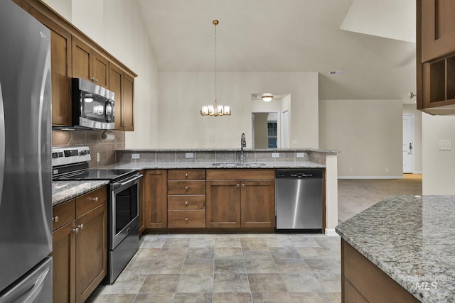 2870 N Cloverdale, Boise, ID 83713 - kitchen with appliances with stainless steel finishes, a peninsula, a chandelier, decorative backsplash, and light stone counters