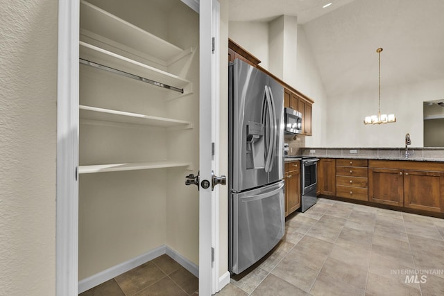 2870 N Cloverdale, Boise, ID 83713 - kitchen with stainless steel appliances, brown cabinets, stone counters, light tile patterned floors, and a chandelier