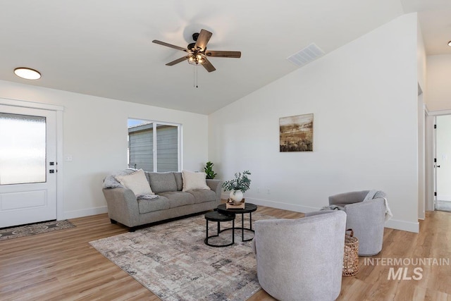 living area featuring visible vents, high vaulted ceiling, a ceiling fan, light wood finished floors, and baseboards