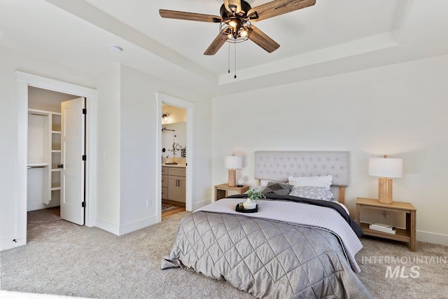 bedroom with baseboards, a raised ceiling, and light colored carpet