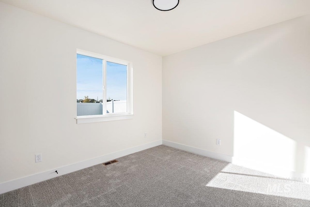 empty room featuring baseboards, visible vents, and carpet floors