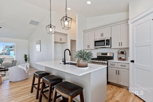 kitchen with a sink, visible vents, light wood-type flooring, and appliances with stainless steel finishes