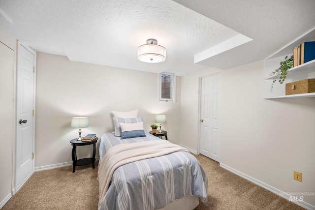 bedroom featuring baseboards, a textured ceiling, and carpet flooring