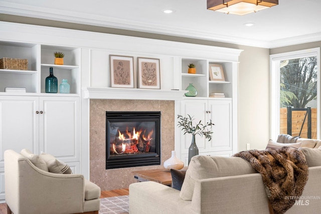 living room featuring recessed lighting, wood finished floors, a fireplace, and crown molding