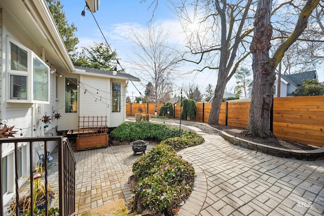 view of patio / terrace with an outdoor fire pit and fence