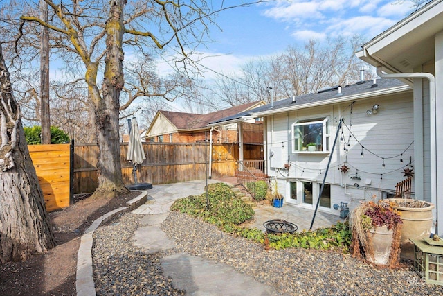 view of yard featuring a patio, a fire pit, and fence