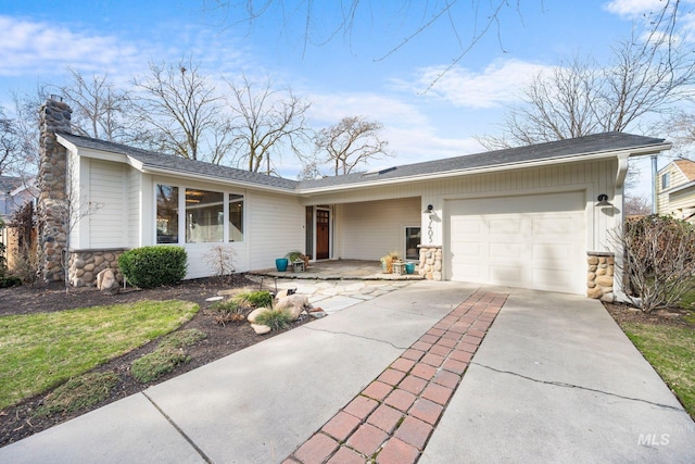 ranch-style house with stone siding, an attached garage, a chimney, and driveway