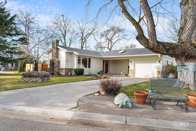 view of front of property with fence, driveway, a chimney, a front lawn, and a garage