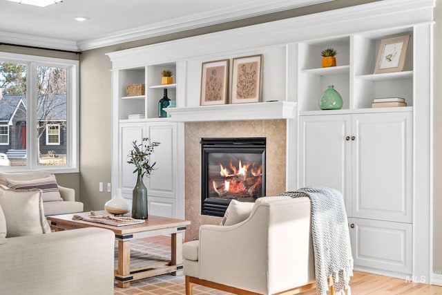 living area with light wood-style flooring, a fireplace, and crown molding