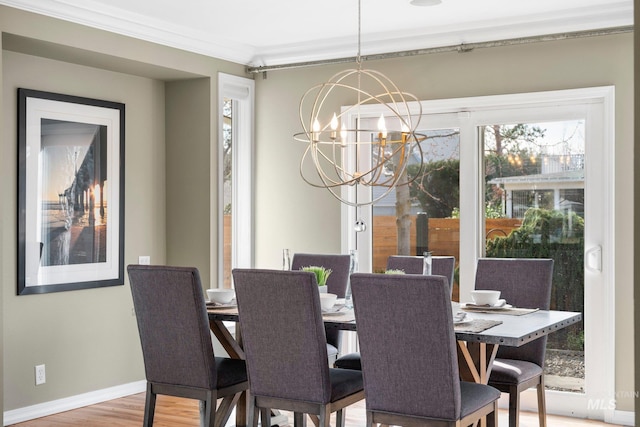 dining space with crown molding, light wood-style floors, baseboards, and a chandelier