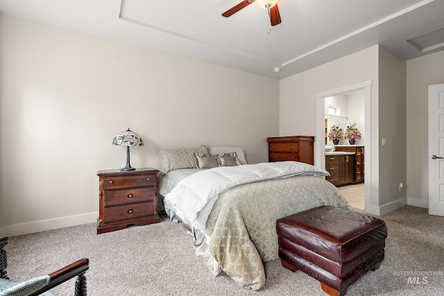 bedroom with light colored carpet, ceiling fan, ensuite bath, and baseboards