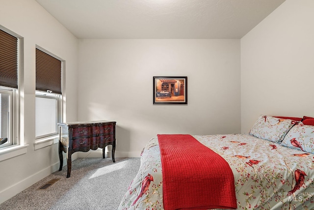 carpeted bedroom with visible vents and baseboards