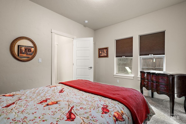 bedroom featuring vaulted ceiling and carpet