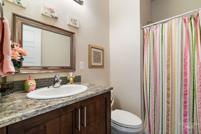 full bath with curtained shower, vanity, and toilet