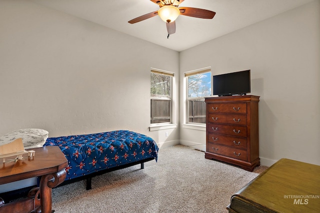 carpeted bedroom with ceiling fan and baseboards