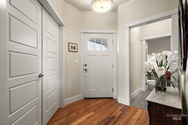 foyer featuring wood finished floors and baseboards