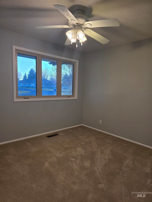 empty room with ceiling fan and carpet floors