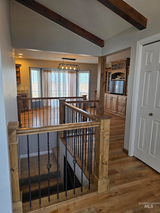 stairs featuring hardwood / wood-style flooring and lofted ceiling with beams